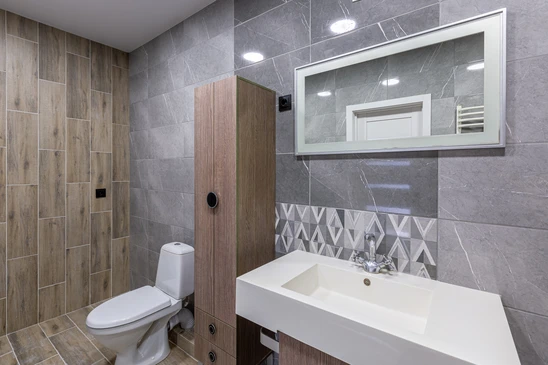 Salle de bain moderne avec carrelage gris marbré aux murs, carrelage imitation bois au sol