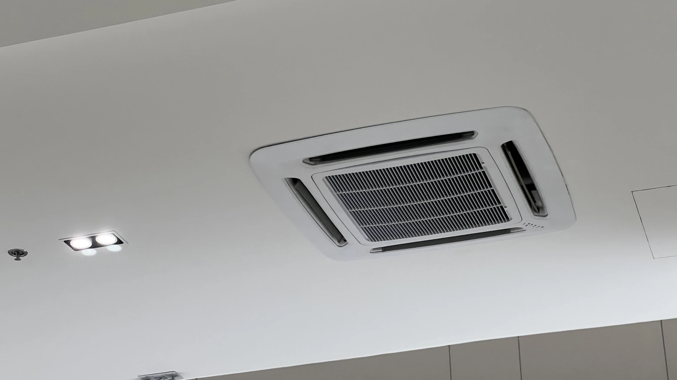 Plafond moderne d'intérieur avec climatiseur cassette carré encastré au centre