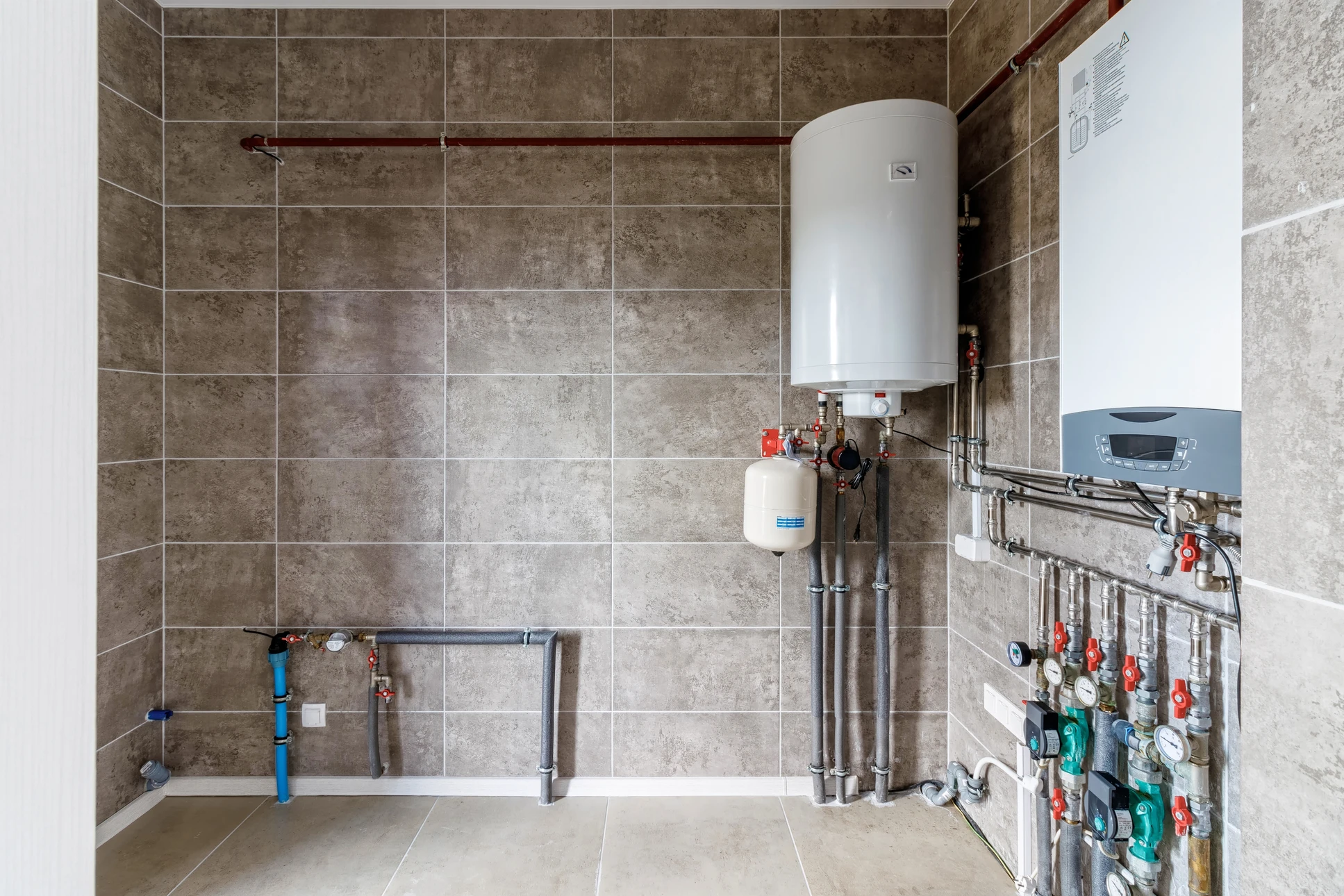 Technicien en plomberie intervenant sur installation de chauffage domestique dans local technique résidentiel